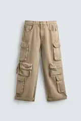 Pantalón cargo de denim color beige claro lavado, de corte relajado y tiro alto. Presenta múltiples bolsillos cargo con solapas y cordones ajustables en las perneras y en el bajo.