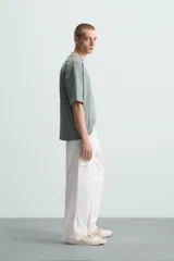 Camiseta gris de corte cuadrado y holgado, con cuello redondo y mangas cortas.