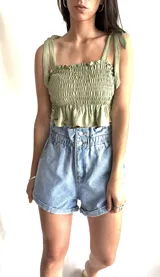 Top negro con textura fruncida, breteles finos con lazos y volado en el ruedo.