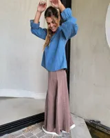 Pollera larga de denim color celeste claro, con corte en A y talle alto con elástico en la cintura.