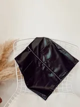 Minifalda negra de ecocuero con cierre metálico frontal y dos bolsillos delanteros.