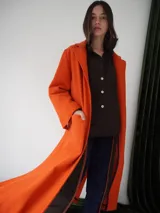 Tapado largo color verde con solapas, bolsillos laterales y cierre con botones.