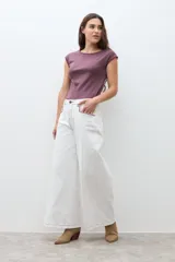 Jean culotte color crudo, de corte ancho y largo hasta el tobillo, con costuras visibles en contraste.