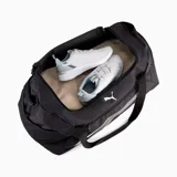 Bolso deportivo Puma Fundamentals mediano, color negro con logo y detalles en blanco. Cuenta con doble asa de mano, correa ajustable para el hombro, bolsillo lateral de malla y compartimento principal con cierre.