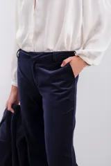 Pantalon estilo oxford confeccionado en terciopelo azul marino, con corte de tiro medio, bolsillos laterales diagonales y cierre frontal oculto.