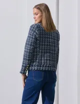 Blazer azul marino de tejido tweed con cuello a la base, apertura central y bolsillos delanteros. Puños con aplique de botones metálicos y terminación desflecada. Forro interno.