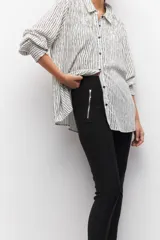 Pantalón chupín elastizado negro con cierres laterales y costuras a lo largo de ambas piernas.