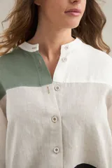 Camisa de lino de calce relajado, con cuello mao, mangas cortas y un diseño de bloques de color en tonos blanco, verde militar, tostado y negro. Cuenta con cierre frontal de botones.