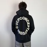 Buzo canguro oversize de color negro con capucha y bolsillo frontal. Presenta un diseño circular estampado en la espalda con letras blancas y bordes dorados.