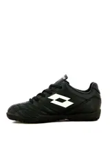 Championes de fútbol 5 Lotto modelo Stadio TF, color negro con el logo de la marca en blanco en el lateral, diseñados para superficies de césped sintético.