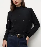 Suéter de punto color negro con cuello medio estructurado y mangas largas. Presenta un patrón geométrico sutil y aplicación de beads distribuidos por toda la parte frontal.