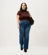 Pantalón de jean recto Ashua, color azul medio con efecto desgastado sutil. Presenta cintura con presillas, cierre frontal con botón y bolsillos funcionales.