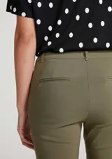 Pantalón de sastre negro de corte ajustado y tobillero, de tiro alto con cierre frontal.