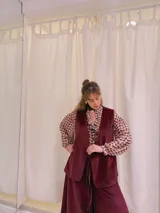 Chaleco largo de terciopelo color bordó, con corte recto y sin cierre.