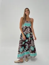 Vestido largo marrón con estampado floral en tonos celeste y blanco, de breteles finos y corte imperio.