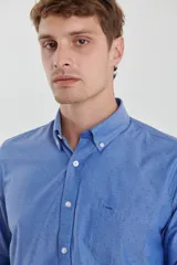 Camisa celeste con micro estampado, de corte clásico, manga larga y cuello abotonado.