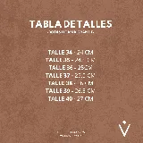 Bota corta tipo chelsea de cuero vacuno color negro, con puntera cuadrada, taco cuadrado de madera y detalle de textura grabada en el panel elástico lateral.