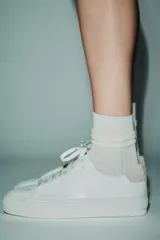 Zapatillas deportivas blancas con detalle de pespuntes a contraste y cordones.