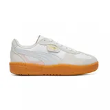 Championes Puma modelo Palermo, de diseño retro con combinación de cuero y gamuza en tonos blanco y beige, con suela de goma color caramelo y detalles en dorado.
