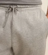 Pantalón deportivo de corte jogger, color negro, con cintura elástica ajustable mediante cordón, bolsillos laterales y puños acanalados en los tobillos. Confeccionado en tejido de algodón con interior felpudo.