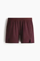 Short deportivo bordó fabricado en tejido funcional con tecnología DryMove, cintura elástica con cordón ajustable oculto y aberturas laterales en el bajo.