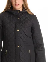 Campera matelassé de largo midi, con diseño combinado de rombos en el cuerpo y costuras horizontales en las mangas. Cuenta con cierre frontal oculto, botones a presión dorados, capucha con interior aterciopelado y ajuste entallado en la cintura.