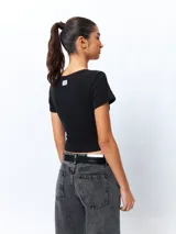 Remera de manga corta color verde lima, ajustada al cuerpo, con un corte cruzado en la parte inferior y un recorte en forma de corazón en el centro del pecho.