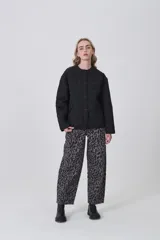 Campera acolchada de diseño capitoneado con patrón de rombos, color negro, de corte holgado, manga larga y cierre frontal con botones a presión.