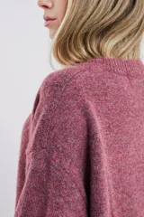 Buzo tejido color gris claro, de corte oversize y cuello redondo.