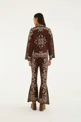 Pantalón oxford tejido de tiro alto, color marrón con estampado estilo paisley en tono crudo, silueta ajustada y botamanga acampanada.
