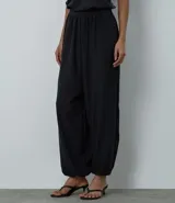 Pantalón modelo aladino de corte holgado, confeccionado en crepé negro. Presenta cintura elástica y puños elásticos en el bajo, con un diseño de volumen tipo globo.