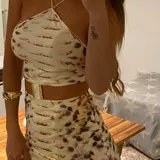 Vestido midi con estampado de piel de serpiente en tonos beige y marrón. Diseño con top halter y falda tubo con abertura lateral.