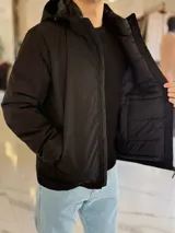 Campera 2 en 1 impermeable de color negro, con diseño con capucha y cierre frontal completo.