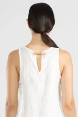 Vestido corto blanco de lino italiano con fibra metalizada, corte holgado y sisas amplias. Presenta cortes redondeados a los costados y la insignia de tigre Polonio en la espalda.