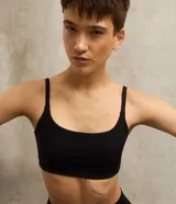 Top deportivo negro con escote recto y tirantes finos, confeccionado en poliamida con elastano.