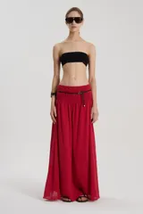 Falda larga roja de bambula de algodón, con cintura ancha elástica, recortes y bolsillos delanteros.