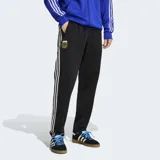 Pantalón deportivo Adidas Originals de la selección argentina, color negro con las icónicas tres tiras blancas laterales. Presenta el escudo de la AFA bordado en el muslo y corte clásico con cintura elástica y cordón de ajuste.
