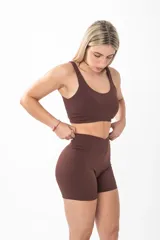 Short deportivo de tiro alto en color negro, con diseño ajustado y logo estampado en la parte posterior de la cintura.