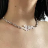 Collar plateado con cadena de eslabones y dije de serpiente calada.