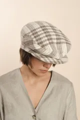 Boina con visera de lana fina uruguaya natural, sin teñir, con diseño de tejido texturizado en tonos beige y marrón.