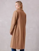 Tapado largo de lana Michael Kors, de corte recto y silueta estructurada. Presenta cuello con solapas amplias, cierre frontal con botones y bolsillos laterales con tapa. Incluye forro interno a tono.