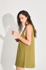 Vestido corto de gabardina color verde oliva, con escote cerrado y silueta amplia.