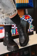 Bota corta de cuero negro con suela track y cierre mediante tiras con velcro en el empeine.