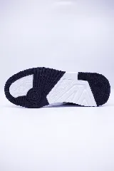 Sneaker de hombre color azul marino con detalles en azul eléctrico y rojo. Presenta un diseño de corte bajo con puntera de gamuza negra, logo de pingüino bordado en blanco con contorno azul, y suela gruesa blanca.