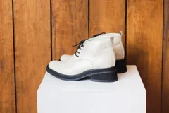 Botinetas de cuero color crema con cordones negros, suela track y plataforma.