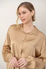 Camisa de satén tramada color blanco, con calce holgado y cómodo, cuello camisero, mangas largas y cierre frontal con botones.