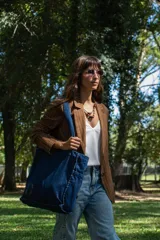 Bolso tipo tote bag confeccionado en denim de color azul oscuro, con costuras reforzadas y diseño espacioso. Cuenta con correas resistentes para llevar al hombro.
