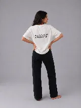 Remera de corte oversize color crudo, con frase estampada en la espalda y logo circular en el frente.