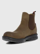 Bota estilo Chelsea color marrón, confeccionada en cuero con paneles elásticos laterales en tono marrón oscuro. Presenta una suela de goma robusta y flexible con tecnología de absorción de impactos y una tira decorativa en la parte trasera con diseño de bandera.