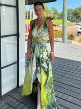 Vestido largo verde con diseño estampado tipo tie-dye y detalles dorados, de corte fluido, un solo hombro y diseño amplio.